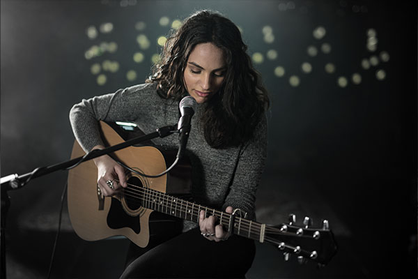 Chica tocando guitarra con micrófono Shure SM86